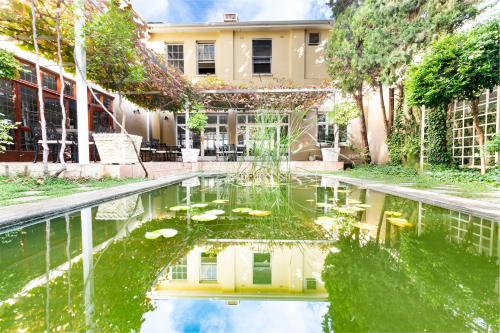 a pool of water with lilies in front of a building at Queen's Hotel by BON Hotels in Oudtshoorn