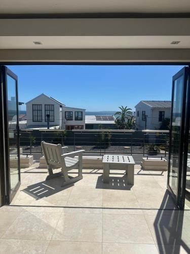 a view of a patio with a bench and a table at Blouberg Village Place in Cape Town