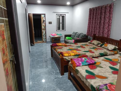 a living room with two beds and a couch at Shreeram Homestay in Gokarn