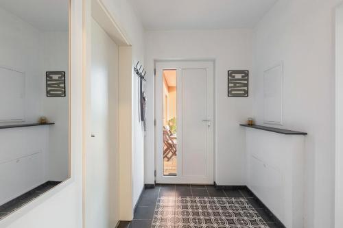 a hallway with a white door and a tile floor at Schöne 2 Zimmer Wohnung Flieden in Flieden
