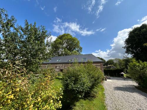 a house with a black roof and some bushes at L'Echo de la nature in Sasseville