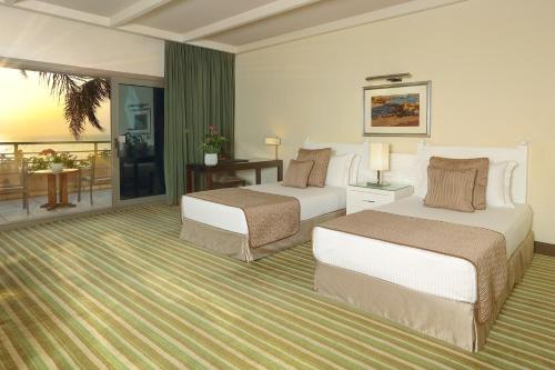 a hotel room with two beds and a balcony at Le Royal Hotel - Beirut in Beirut
