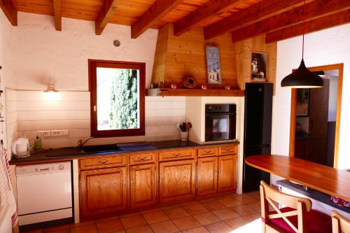 une cuisine avec des armoires en bois et un comptoir dans l'établissement Chalet JEANMARIKA, à Campan