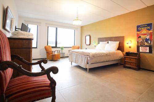 a hotel room with a bed and a chair at Les chambres du Donat in Sainte-Cécile