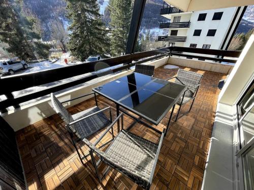 un patio avec une table et des chaises sur un balcon dans l'établissement Very nice apartment, slopeside, à Saint-Chaffrey