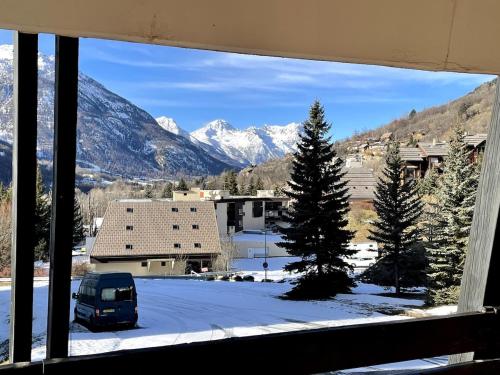 - une vue sur une montagne enneigée depuis une fenêtre dans l'établissement Very nice apartment, slopeside, à Saint-Chaffrey