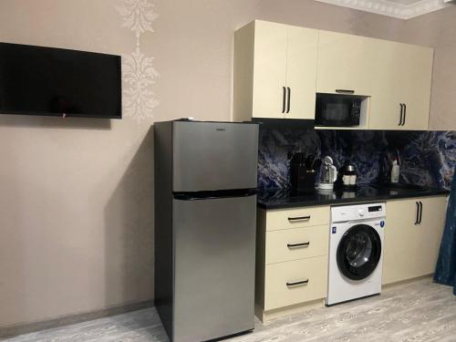 una cocina con nevera y lavadora en SAMO GUEST Home, en Kapreshumi