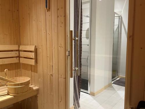 La salle de bains est pourvue de murs en bois et d'une douche en verre. dans l'établissement Grand appartement vue Montagne plein sud grand garage sur demande, à Font-Romeu