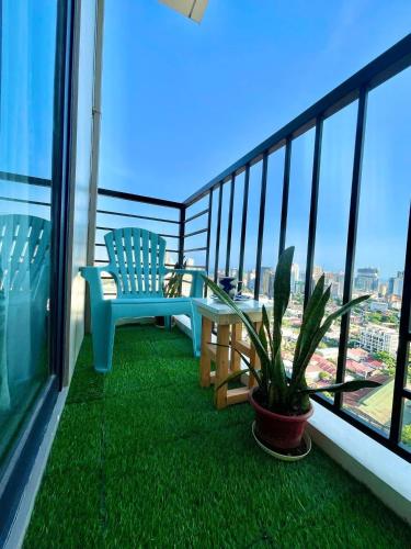 een balkon met een blauwe bank en een potplant bij Overlooking City View in Cebu City