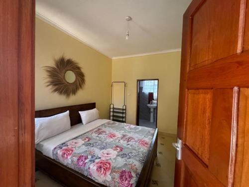 a bedroom with a bed with a floral bedspread at Town Retreat Moshi in Moshi