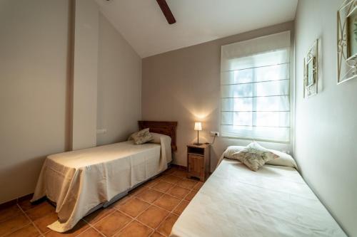 ein Schlafzimmer mit zwei Betten und einem Fenster in der Unterkunft Casa el Rincón del Lago Alojamiento Rural in Córdoba