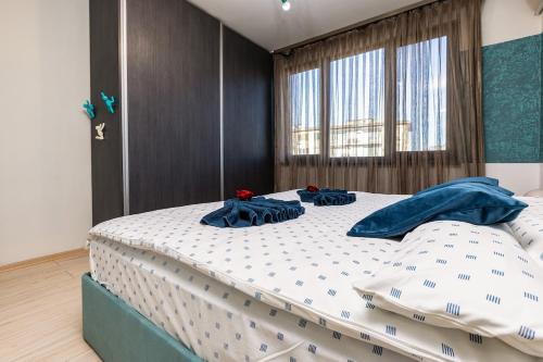 a bedroom with a large bed with blue pillows on it at Nikolaos Apartment by Flat Mаnager in Plovdiv