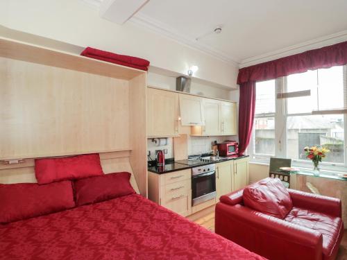 a bedroom with a red bed and a red couch at 9 Old City Chambers in Bristol