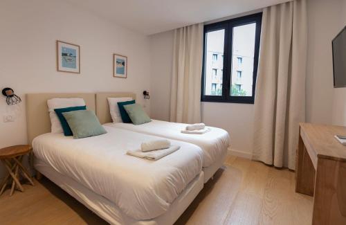 deux lits jumeaux dans une chambre avec fenêtre dans l'établissement LE STANDING - Appartement de haut standing proche du port, à Antibes