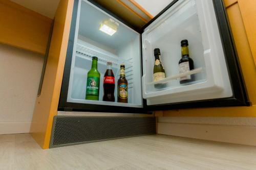 an open refrigerator filled with lots of bottles of beer at Ristorante Pensione Chalet Stazione in Poschiavo