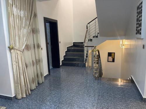 a hallway with stairs and a black door at Your Luxury Home away from Home in Gwarinpa