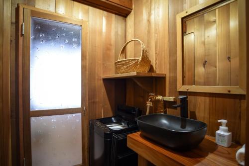 a bathroom with a black sink on a counter at The Cabin in Hakuba