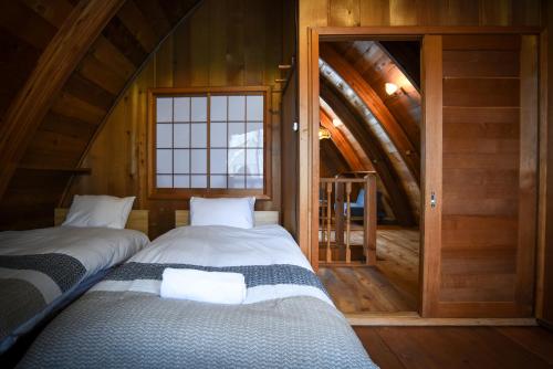 two beds in a room with an attic at The Cabin in Hakuba