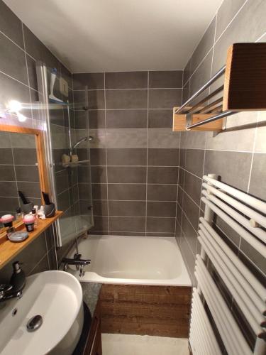 une salle de bain avec une baignoire et un lavabo dans l'établissement Annapurna LA CLUSAZ, à La Clusaz