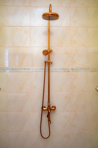 eine Dusche im Bad mit einer Wand in der Unterkunft Hôtel L'apéro in Cotonou