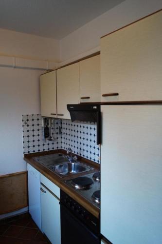 a small kitchen with a sink and a stove at Huus Westerdiek in Dornum
