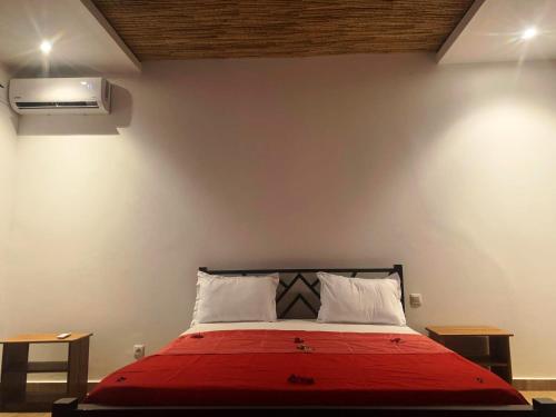 a bedroom with a bed with a red blanket at Résidence Kanissa in Cap Skirring