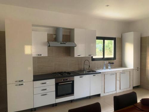 a kitchen with white cabinets and a stove top oven at Résidence Kanissa in Cap Skirring