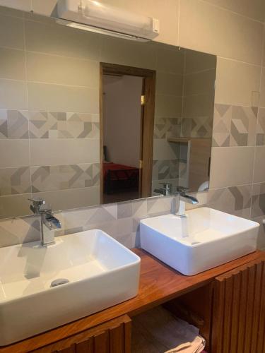 a bathroom with two sinks and a large mirror at Résidence Kanissa in Cap Skirring