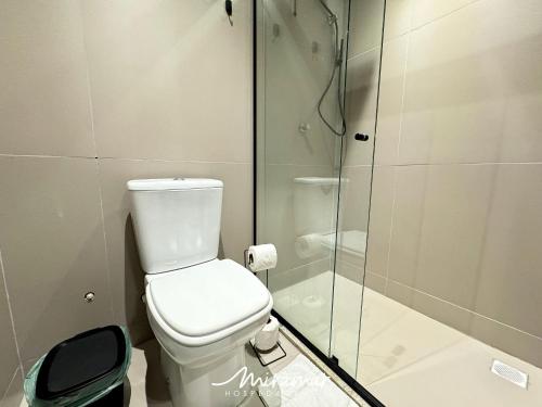 a bathroom with a toilet and a glass shower at Beach Haus in Tambaú