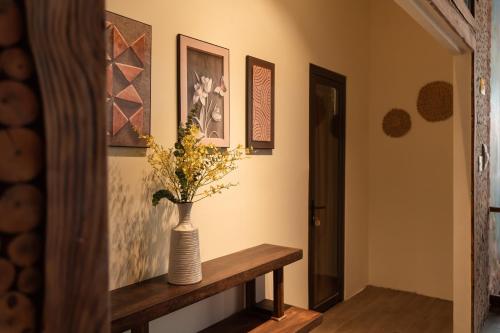a vase with flowers on a table in a room at D Banlieue Homestay And Coffee TP Kon Tum in Kon Tum