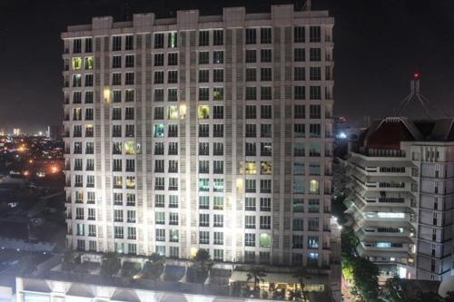 a large white building with many windows at night at The Square - King Suite - Apartemen Service - 2Person - NetFlix Wifi - Near Petra Campus in Surabaya