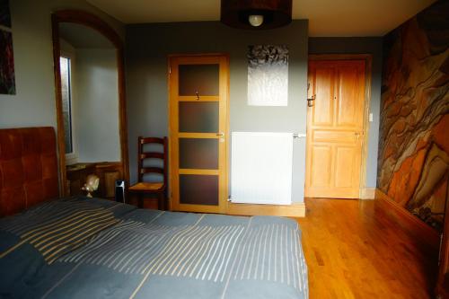 a bedroom with a bed next to a door at Chambre et pièce à vivre bucolique in Saint-Pal-de-Mons