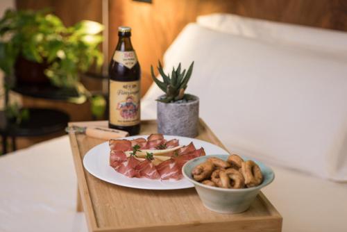 a table with a plate of food and a bottle of beer at Cà Toresele Relais Osteria Garden in Verona