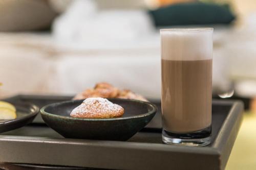 a tray with two plates of donuts and a glass of coffee at Cà Toresele Relais Osteria Garden in Verona