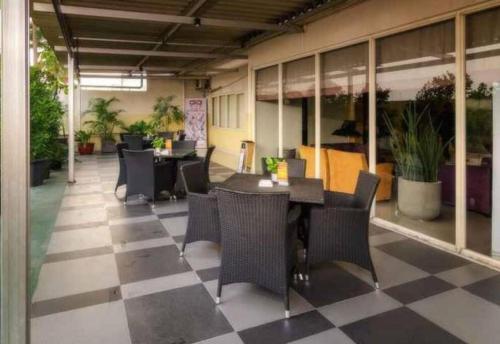 a restaurant with tables and chairs on a checkered floor at The Square - King Suite - Apartemen Service - 2Person - NetFlix Wifi - Near Petra Campus in Surabaya