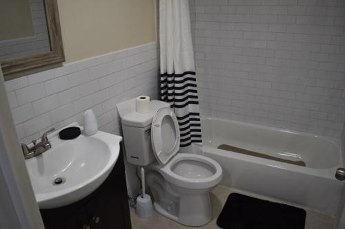 a bathroom with a white toilet and a sink at West Babylon Bliss in West Babylon
