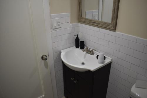 a white bathroom with a sink and a mirror at West Babylon Bliss in West Babylon