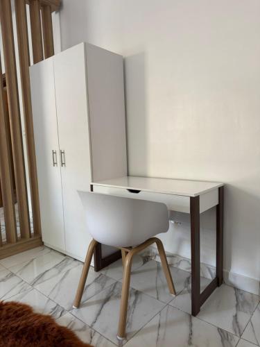 a white desk and a chair in a room at logement luxueuse au pieds du monument de la renaissance africaine in Dakar