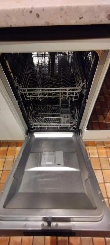 un lave-vaisselle vide avec des porte-métaux. dans l'établissement Le Bellevue de la Viotte, à Besançon