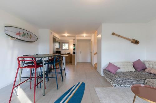 un salon avec une table, des chaises et un canapé dans l'établissement Seignosse- Terraced Villa -Ocean-Family, à Seignosse