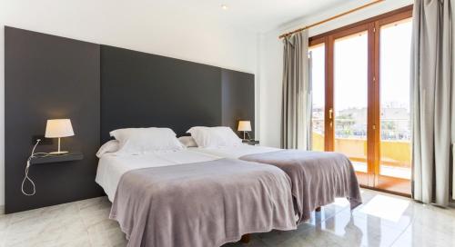 a bedroom with two beds and a black wall at Ca Nostra in Son Servera
