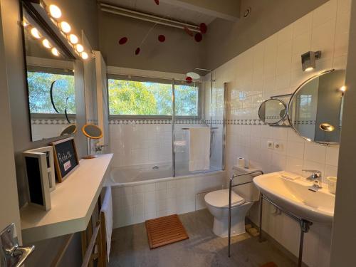 une salle de bain avec un lavabo, des toilettes et une baignoire dans l'établissement La Maison de Jane Château&Beauval, à Cormeray