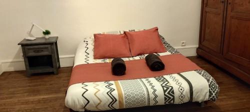 une chambre avec un lit avec deux oreillers dessus dans l'établissement Le Bellevue de la Viotte, à Besançon