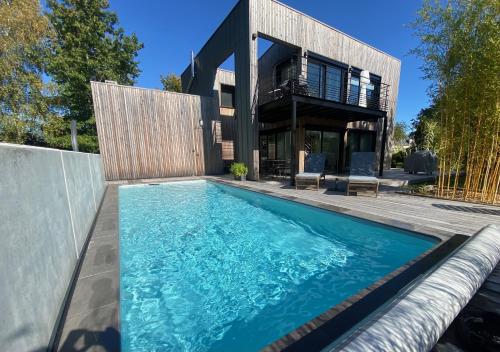une piscine devant une maison dans l'établissement La Maison de Jane Château&Beauval, à Cormeray