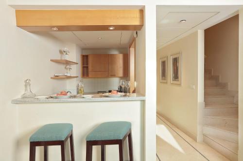 a kitchen with two stools at a bar in a house at Le Royal Hotel - Beirut in Beirut
