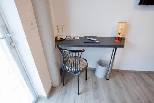 a desk with a chair next to a wall at Ristorante Pensione Chalet Stazione in Poschiavo