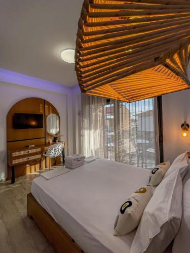 a bedroom with a large bed and a television at Bamboo Luxury Studios in Nikiti