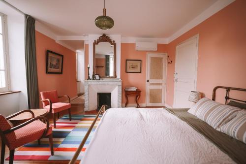 a bedroom with a bed and a fireplace at Les Chambres de Lasserre - Chambres et Table d'hôtes in Lasserre