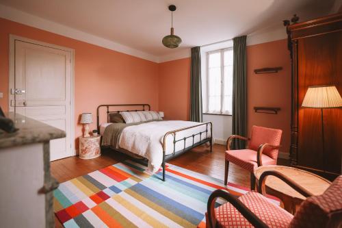 a bedroom with a bed and a colorful rug at Les Chambres de Lasserre - Chambres et Table d'hôtes in Lasserre