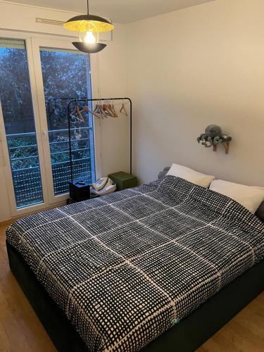 une chambre avec un lit à carreaux noirs et blancs dans l'établissement Appartement Paisible au Vert, à Saint-Ouen
